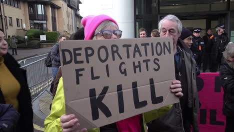 UK-February-2019---A-woman-protestor-in-a-pink-wool-hat-stands-holding-a-placard-that-says,-“Deportation-Flights-Kill”