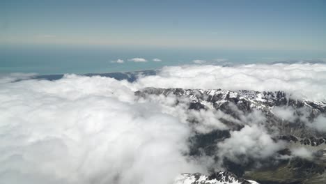 Toma-Aérea-Desde-Un-Vuelo-Panorámico-Sobre-La-Costa-Oeste-Del-Glaciar-Fox-Aoraki-Mount-Cook,-Parque-Nacional-Con-Nubes,-Montañas-Rocosas-Nevadas-Y-Océano-En-El-Fondo