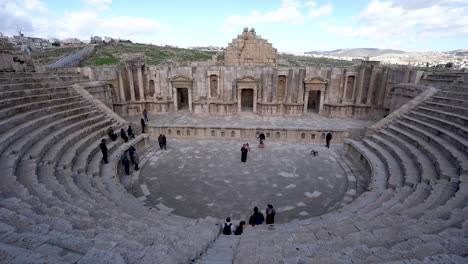 Eine-Gruppe-Schwarz-Gekleideter-Beduinen-Spielt-Musik-Mit-Dudelsäcken-Für-Eine-Gruppe-Von-Touristen-Im-Alten-Nordtheater-Von-Jerash-In-Römischen-Ruinen