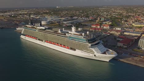 Toma-Aérea-Del-Crucero-En-El-Muelle-Alejándose-Con-La-Isla-En-El-Fondo-4k