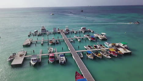 Boats-at-a-dock-in-the-beautiful-blue-Caribbean-Sea-in-Palm-Beach,-Aruba