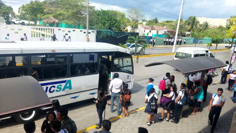 Turistas-Subiendo-A-Un-Autobús-De-Tránsito-Con-Mochilas-Y-Uniformes-Escolares-En-México-En-Una-Calle-Muy-Transitada