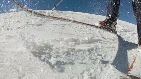 Slow-motion,-taking-down-snow-from-ski-that-goes-direct-to-the-camera