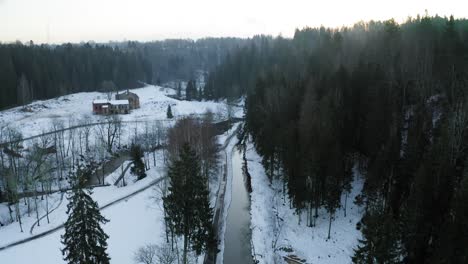 Flying-over-small-river-during-winter-in-small-village