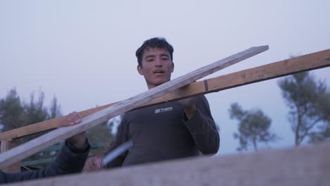 Afghan-refugees-construct-shelter-marking-beam-to-cut