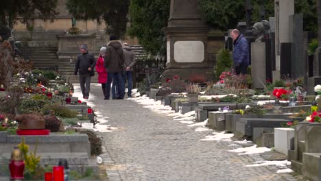 Tiro-Deslizante-En-Movimiento-A-La-Izquierda-A-Través-Del-Cementerio-En-Praga-Con-Personas-Moviéndose-A-Través-Del-Marco