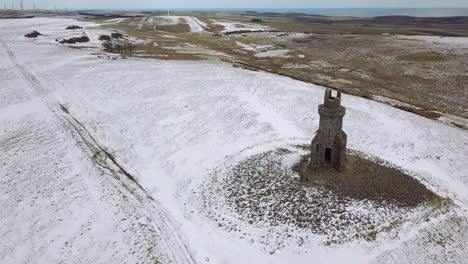 Aerial-footage-of-St-Johnstons-Mount-monument-in-the-snow-on-a-winters-day-in-Aberdeenshire,-Scotland