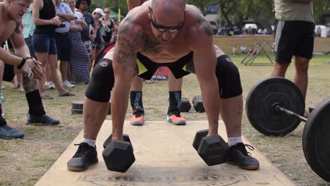 Enge-Aufnahme-Eines-Fitten-Tätowierten-Athleten,-Der-Bei-Einem-Cross-Fit-Wettkampf-Einen-Hantel-Burpee-Snatch-Durchführt