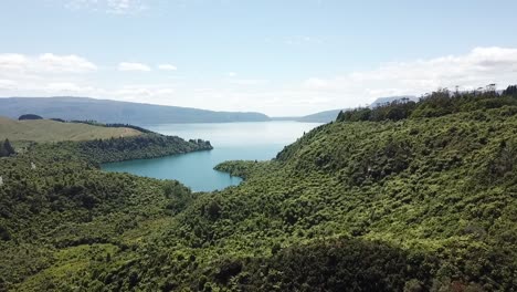Drone-view-of-the-hills-at-Waimangu-valley,-with-a-lake-in-the-background