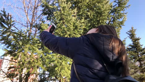 Slowmo-Eines-Jungen-Mädchens,-Das-Selfies-Mit-Einem-Smartphone-Mit-Frontkamera-In-Einem-Stadtpark-Macht