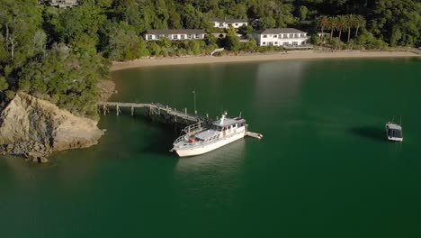 SLOWMO---Cruise-boat-docked-in-bay-during-summer-in-Marlborough-Sounds,-New-Zealand