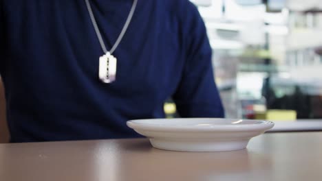 Man-Sitting-At-Table-In-A-Small-Coffee-Shop-And-Drink-A-Cup-Of-Segafredo-Cafe