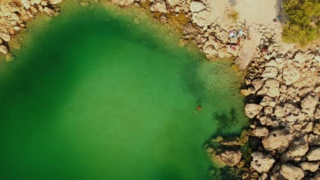 Drohnenblick-Auf-Einen-Kleinen,-Von-Felsen-Umgebenen-See