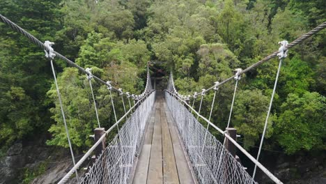 Caminando-Sobre-El-Puente-Colgante-En-El-Desfiladero-De-Hokitika,-Nueva-Zelanda