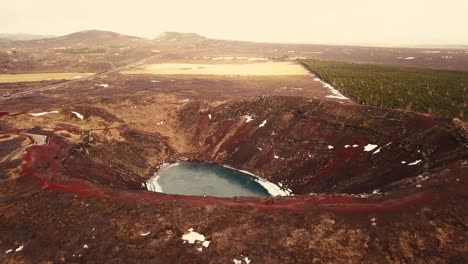 Different-drone-moves-show-Kerid-crater-in-Iceland,-in-a-semi-frozen-landscape