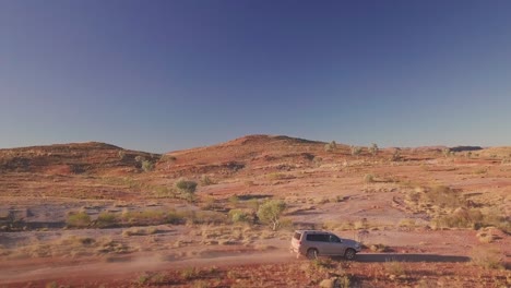 Drone-Aéreo-Rastreando-Un-Camión-4wd-Por-Un-Camino-De-Grava-En-El-Desierto-Australiano