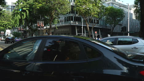 Singapur---Alrededor-De-Una-Toma-Panorámica-Lenta-Del-Tráfico-Acelerado-En-Una-Concurrida-Intersección-En-Orchard-Road,-Singapur