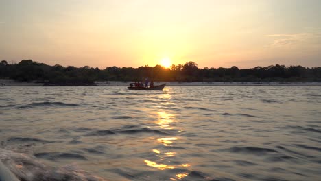 Kleines-Fischerboot-überquert-Ein-Anderes-Boot-Bei-Einem-Sonnenuntergang-Im-Amazonas-Dschungel