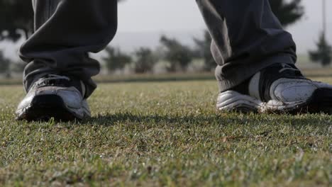 Close-up-of-a-golfer-using-a-hybrid-iron-on-the-fairway,-slow-motion-and-low