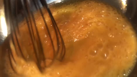 Slow-motion-shot-of-whisk-beating-eggs-in-a-reflective-bowl-in-preparation-of-baking-cakes-for-Easter