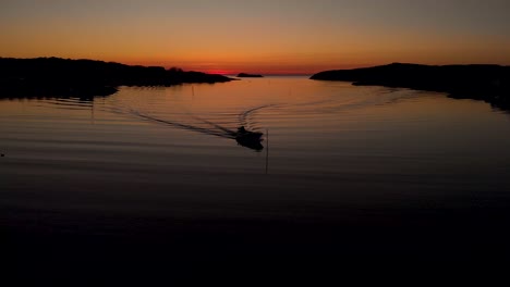 Drohne-Fliegt-In-Der-Nähe-Eines-Kleinen-Bootes-Mit-Sonnenuntergang-Im-Hintergrund