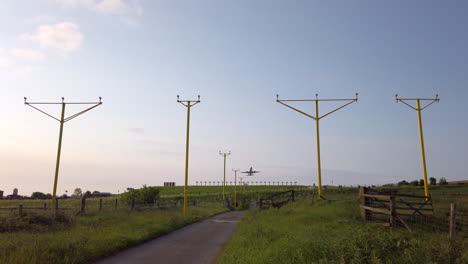 Tiro-Estático-En-Cámara-Lenta-Del-Avión-Que-Sale-Del-Aeropuerto-Internacional-De-Leeds-Bradford-En-Yorkshire-En-La-Hermosa-Mañana-De-Verano-Con-Sistema-De-Iluminación-De-Aproximación-En-Primer-Plano