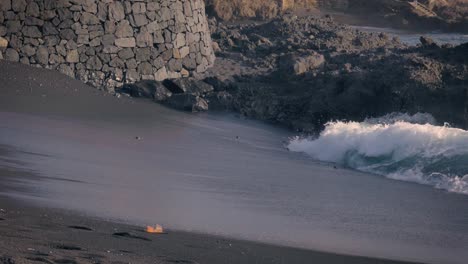 Beautiful-black-sand-beach-of-Tenerife-with-waves-washing-over-the-shore-in-slow-motion