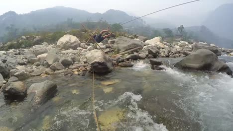 Ein-Trainer-Eines-Bergsteigerinstituts-Im-Himalaya-überquert-Den-Gebirgigen-Fluss-Mit-Einem-Seil-Und-übt,-Den-Fluss-Mit-Einem-Seil-Zu-überqueren