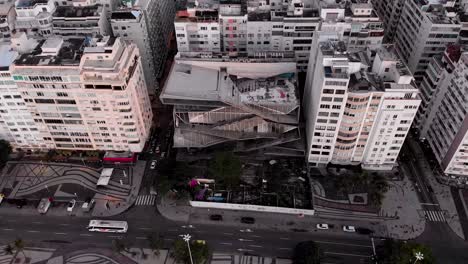 Luftaufnahme-Des-Copacabana-viertels-In-Rio-De-Janeiro-In-Den-Frühen-Morgenstunden-Mit-Dem-Strand-Und-Dem-Boulevard-Im-Vordergrund-Und-Der-Skyline-Der-Stadt-Im-Hintergrund