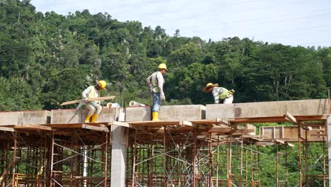 Construction-workers-installing-timber-form-works-and-rain-water-down-pipes-at-the-construction-site