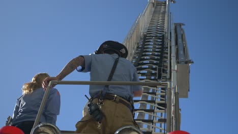 Operador-De-Bomberos-Una-Larga-Escalera-De-Rescate-En-La-Parte-Superior-De-Un-Camión-De-Bomberos