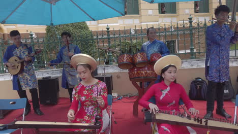 Orquesta-Con-Vestidos-Coloridos-Tocando-Instrumentos-Tradicionales-En-Un-Concierto-Callejero