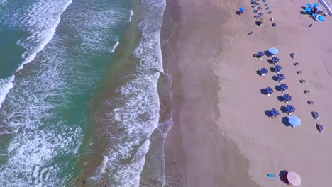 Bird´s-eye-view-of-the-coastline-Boca-del-Rio-beach,-image-from-the-heights-of-how-the-beach-looks,-with-serene-waves-and-white-sand,-the-umbrellas-accompany-the-coming-and-going-of-the-sea