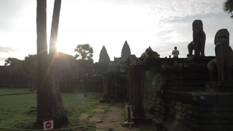 Tourists-walking-at-Angkor-Wat-temple-ruins-in-Siem-Reap,-Cambodia-at-sunrise