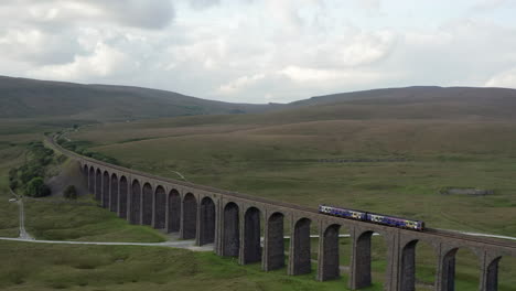 Aerial-Shot-of-a-Northern-Train-Crossing-Ribblehead-Viaduct-in-the-Yorkshire-Dales-from-Left-to-Right