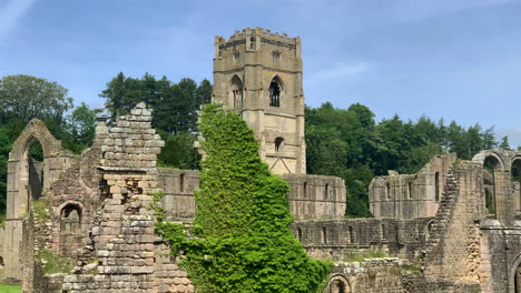 Static-Shot-of-Cistercian-Monastery-Ruins-in-North-Yorkshire-on-a-Beautiful-Summer’s-Day-with-Trees-Blowing-in-the-Breeze-in-Slow-Motion