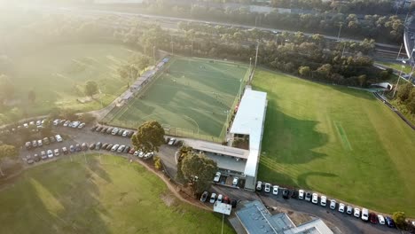 Aerial-drone-footage-flying-into-the-sun-and-down-towards-Elgar-Park-field-hockey-ground