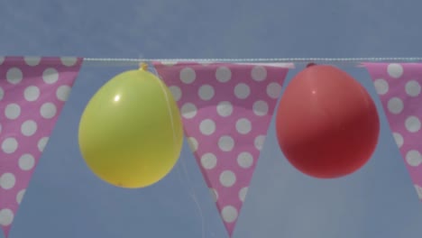 Bunting-Polka-Dot-Mit-Luftballons-Gegen-Den-Blauen-Himmel