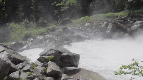 Splashing-water-from-a-waterfall-in-the-wood-of-the-Italian-Alps-in-summer,-slow-motion-100-fps
