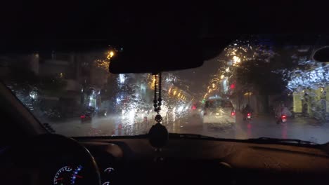 Ver-A-Través-De-La-Ventana-Del-Taxi-Bajo-La-Lluvia-Tropical-Torrencial-Por-La-Noche-Con-Las-Deslumbrantes-Luces-De-La-Ciudad-De-Ho-Chi-Minh-El-Sábado-Por-La-Noche