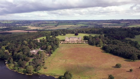 Aerial-Flyaway-with-Tilt-of-Harewood-House,-a-Country-House-in-West-Yorkshire,-from-Front-on-Angle