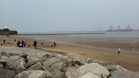 Old-fort-on-New-Brighton-beach-people-on-beach-and-cranes-across-the-Mersey