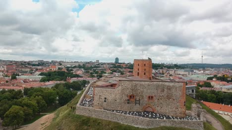 Aerial-shot-of-Gediminas-Tower-in-Vilnius,-with-a-partial-view-of-the-entire-city-at-the-foreground