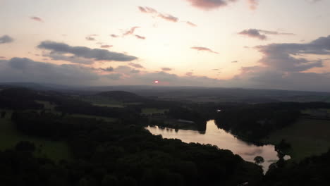 Left-to-Right-Aerial-Shot-of-a-Country-Estate-and-Lake-during-Sunset