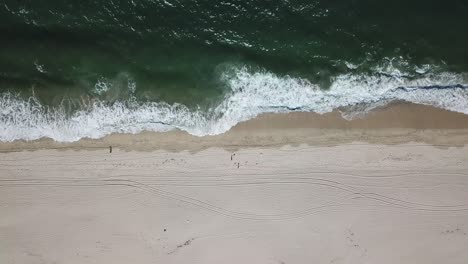 Luftaufnahme-Von-Oben-Nach-Unten-Von-Schäumenden-Grünen-Wellen-Der-Halbmondförmigen-Strandpfanne-Rechts