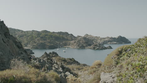 Panoramablick-Auf-Menschen,-Die-Am-Strand-In-Der-Nähe-Des-Leuchtturms-In-Cap-De-Creus-In-Spanien-Entspannen-Und-Spielen