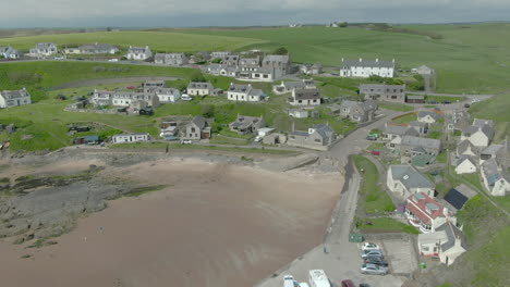 An-aerial-view-of-Collieston-village-from-the-sea-on-a-cloudy-day