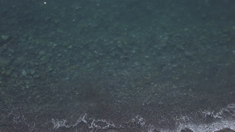 Transparent-clear-sea-in-the-rocky-beach-shore-aerial-view