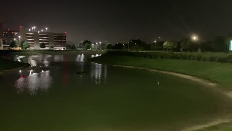 A-short-clip-of-a-pond-next-to-a-hospital-at-night-in-Katy,-Texas