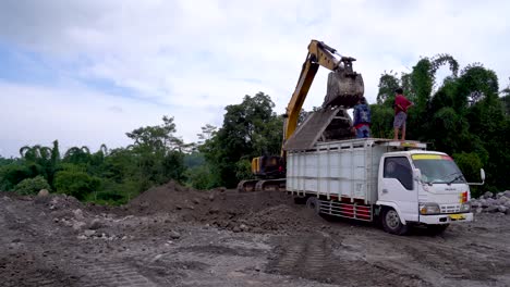 Excavator-removing-tailgate-used-to-filtrate-sand-after-loading-dump-truck